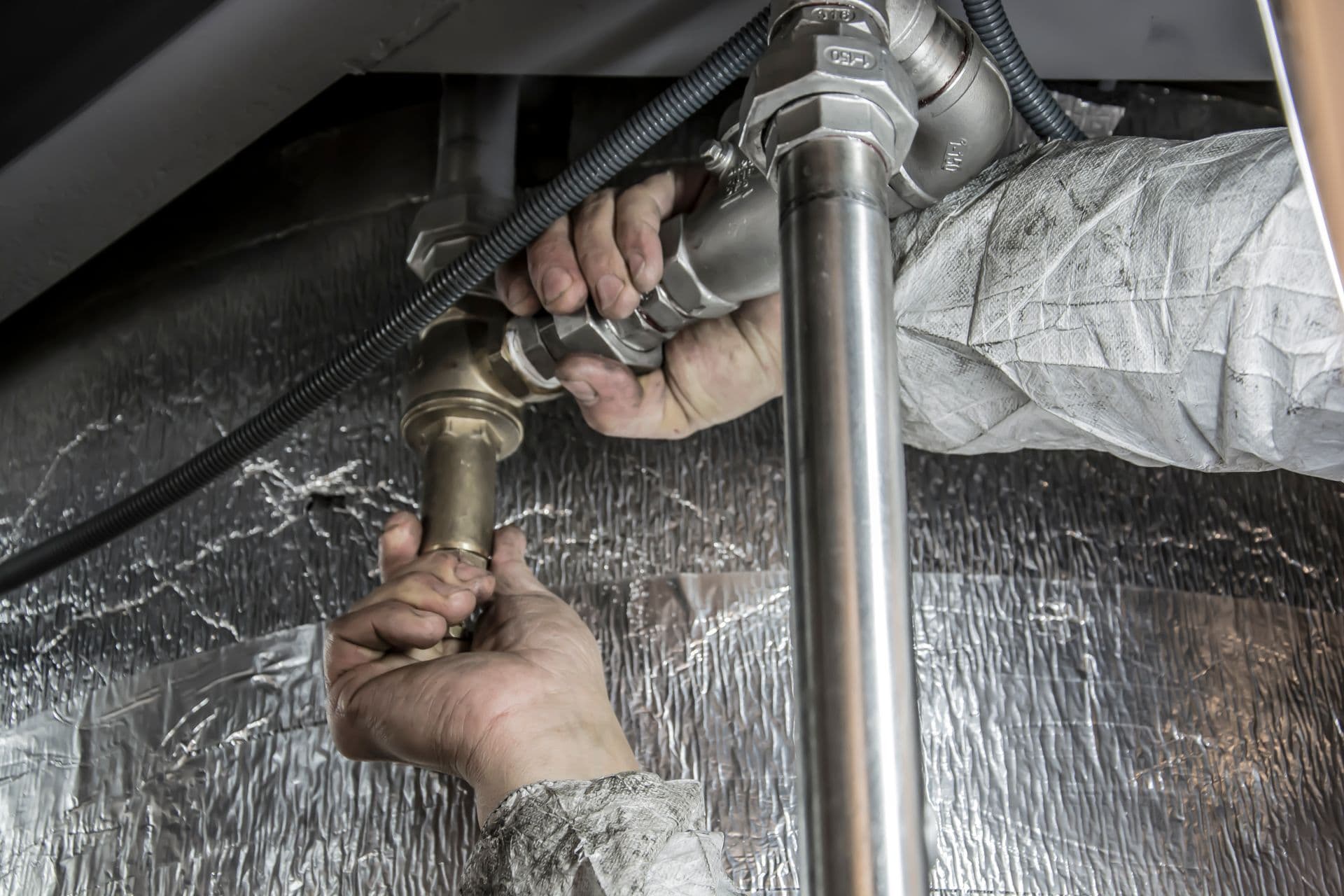 Plumber assembling brass and steel pipe fittings